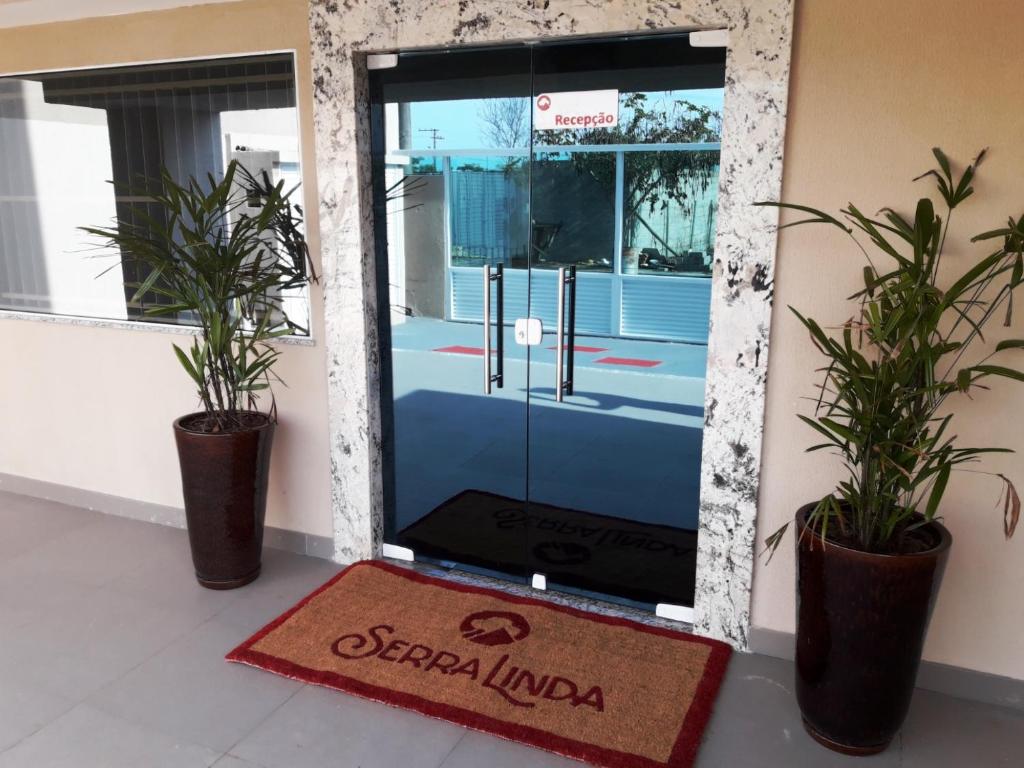 塞拉Serra Linda Hotel的两棵盆栽植物的楼房里的一个门