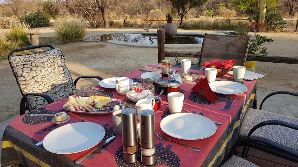 奥马鲁鲁Camp Mara的餐桌上放有食物盘子的桌子