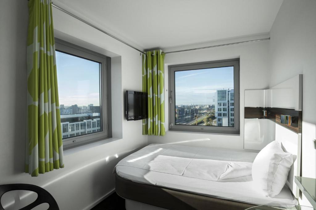 哥本哈根哥本哈根醒来酒店 - 卡斯滕尼布尔斯盖德的一间卧室设有一张床和两个窗户。