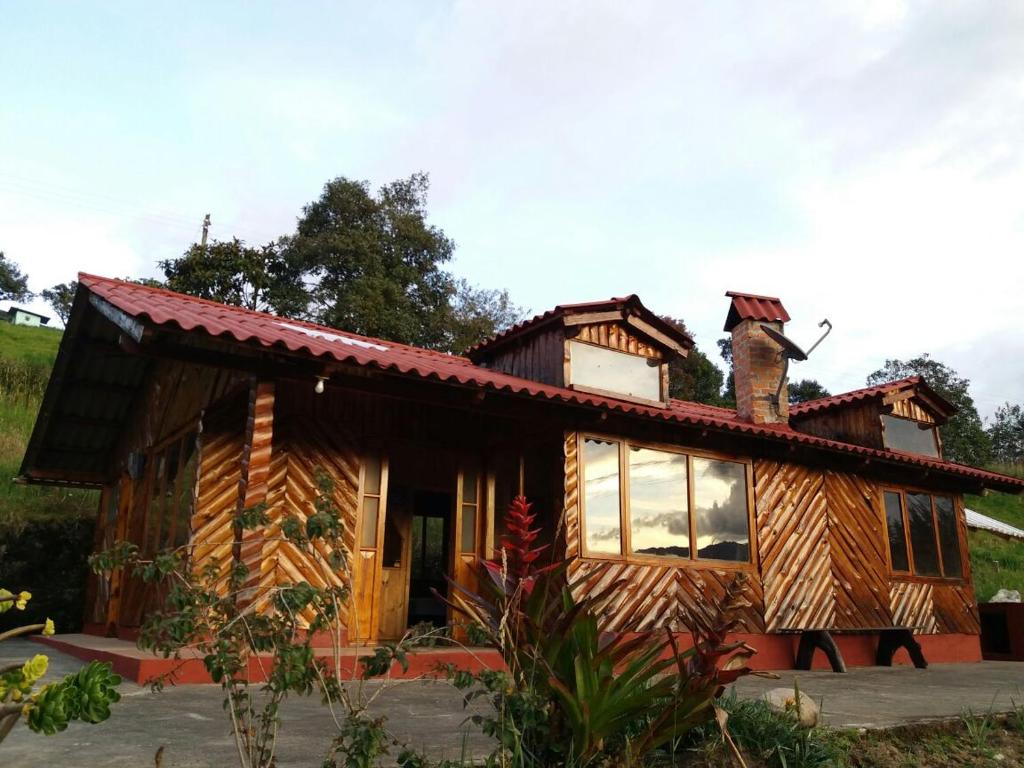 El EncanoCASA LA KOCHA, Cabin, Hostal en la Laguna de la Cocha的小木屋的顶部设有烟 ⁇ 