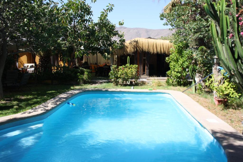科皮亚波Tikay Suite Hotel的一座大蓝色游泳池,位于房子前