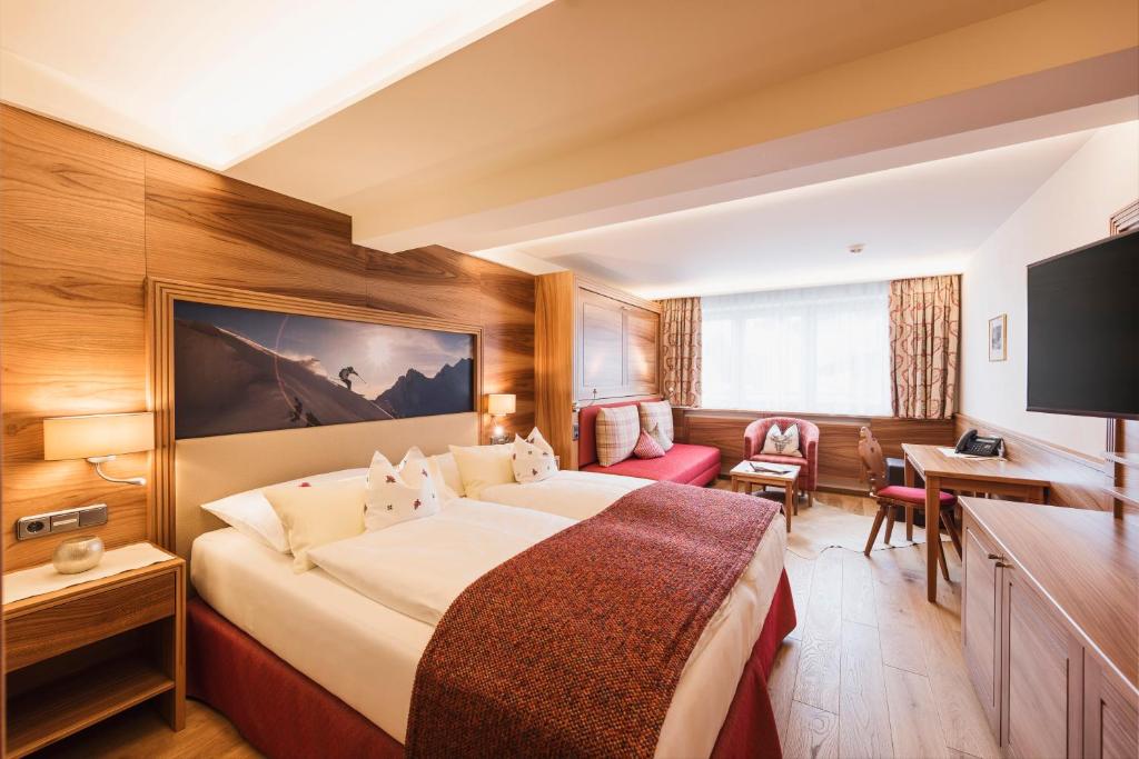 祖尔斯阿尔伯格酒店的酒店客房设有一张大床和一张书桌。