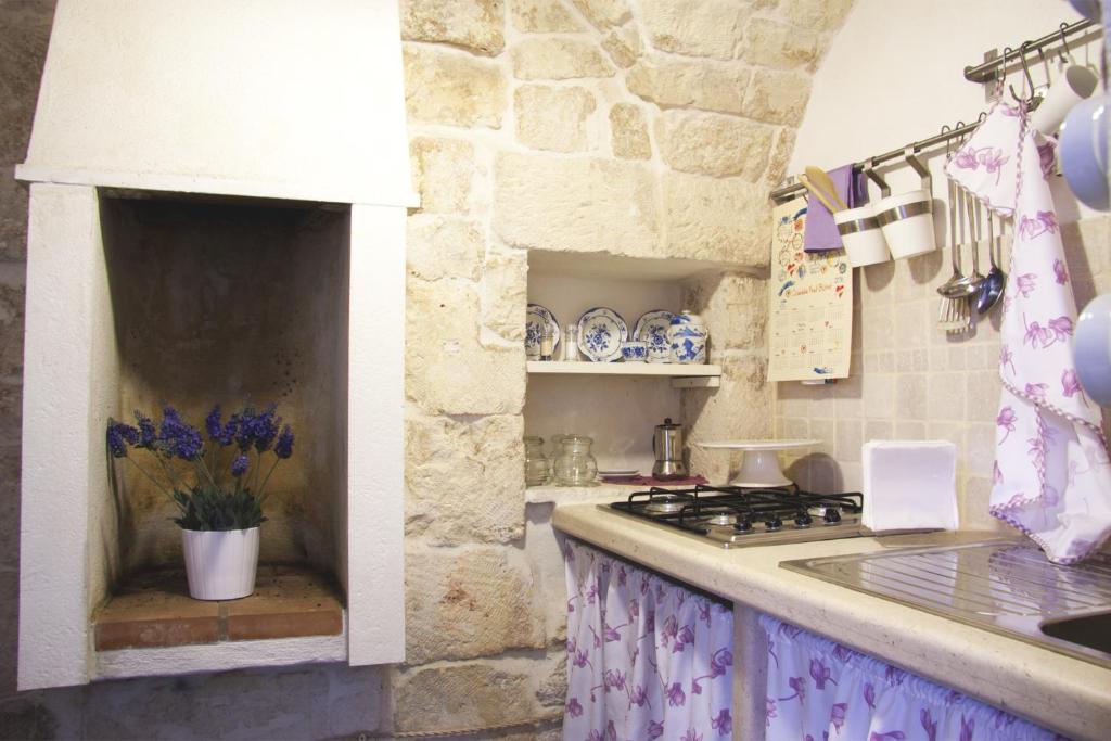 奥斯图尼Casa Angelica的厨房配有炉灶和石墙