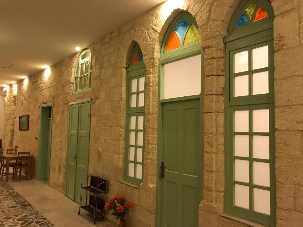 拿撒勒Al Bishara Guest House的建筑物内一排绿门窗