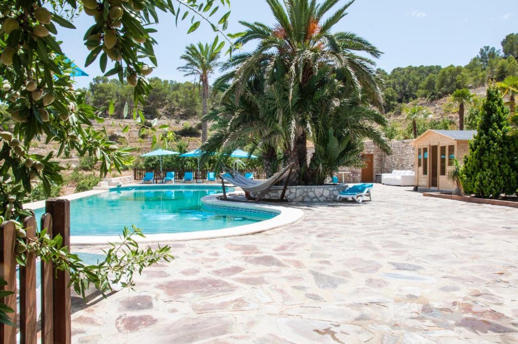 RelleuFinca El Almendral的一个带吊床和棕榈树的度假游泳池