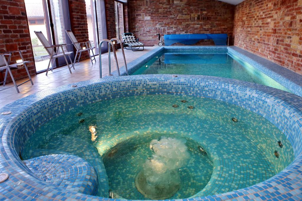 久洛Woodland Villa的砖墙客房内的大型小型游泳池