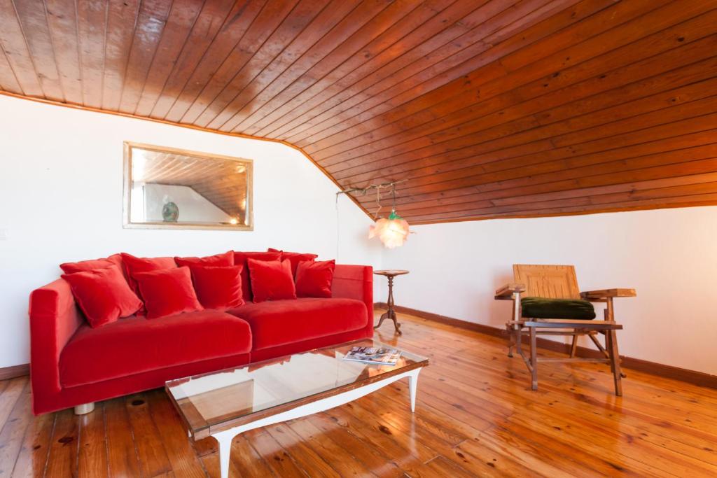 里斯本Bairrus Lisbon Apartments - Alfama III的客厅设有红色的沙发,拥有木制天花板
