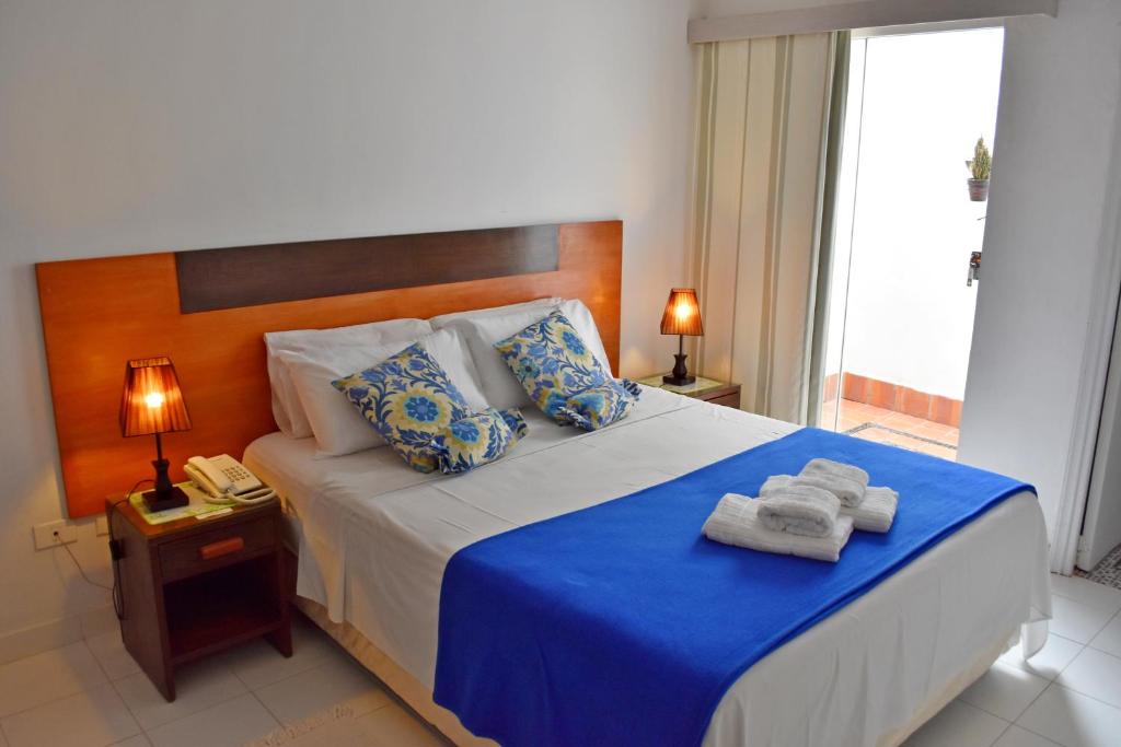 亚松森Giuseppe Suites Hotel的一间卧室配有一张大床和毛巾