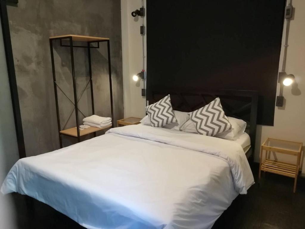 曼谷Dreamcatcher Bangkok的卧室里有一张大床，床单和枕头都是白色的