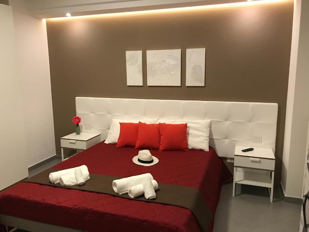 格拉维纳普利亚My Home的一间卧室配有一张带红色和白色枕头的大床