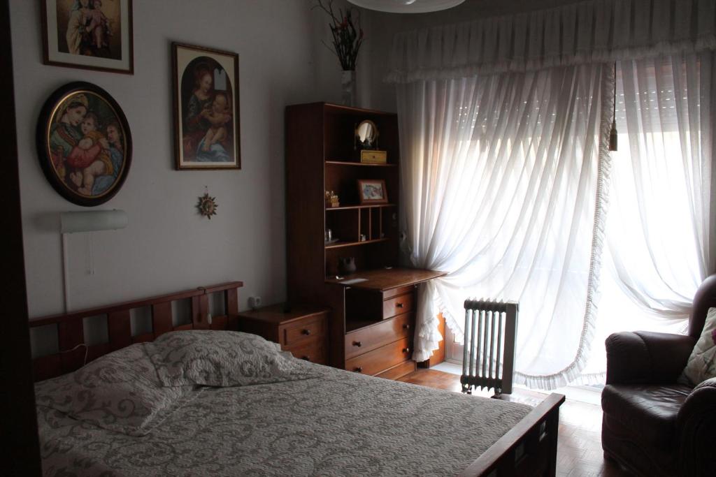 波尔图波尔图套房民宿的卧室配有床、椅子和窗户。