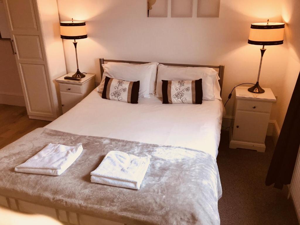 伦敦安格斯坦酒店 的一间卧室配有一张床,上面有两条毛巾