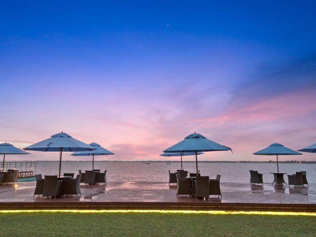 尼甘布Amagi Aria Airport Transit Hotel的海滩上一组桌椅和遮阳伞