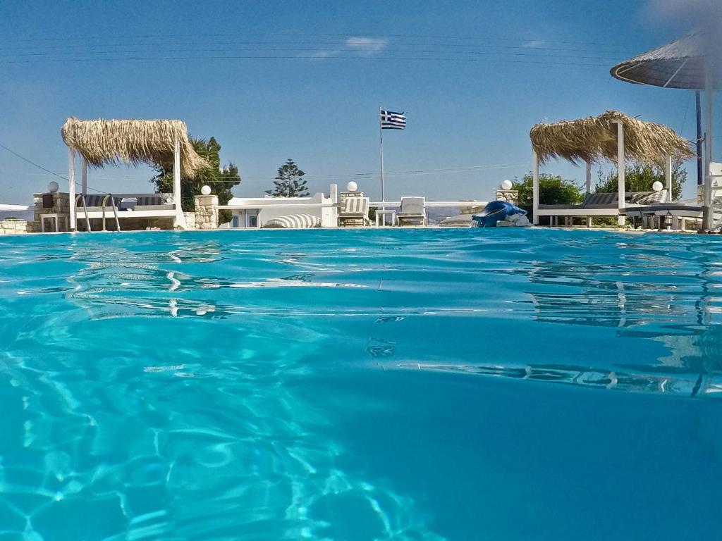 安倍拉斯安倍拉斯玛格丽塔一室公寓酒店的一个带椅子和遮阳伞的蓝色海水游泳池