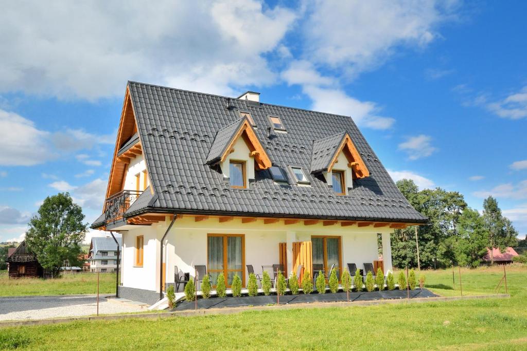 维托韦Toporowe Domki w Chochołowskiej的一间黑色屋顶的白色小房子