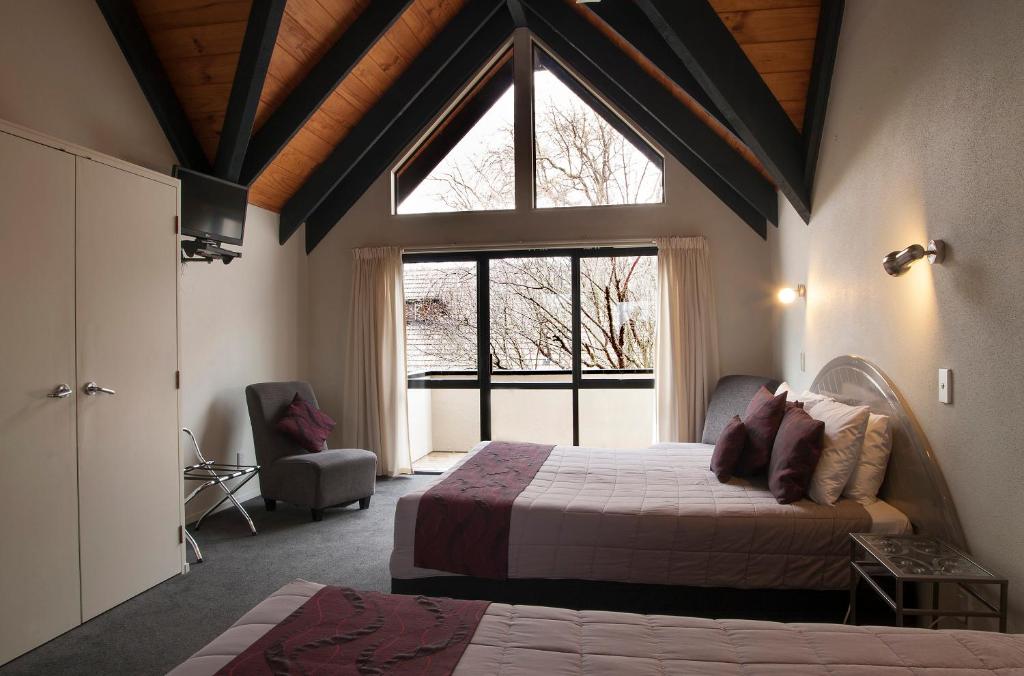 罗托鲁瓦威利苑汽车旅馆的一间卧室设有两张床和大窗户
