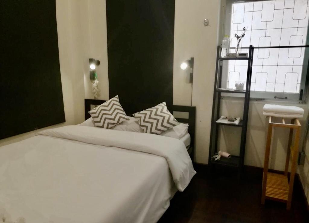 曼谷Dreamcatcher Bangkok的一间卧室配有带白色床单和枕头的床。