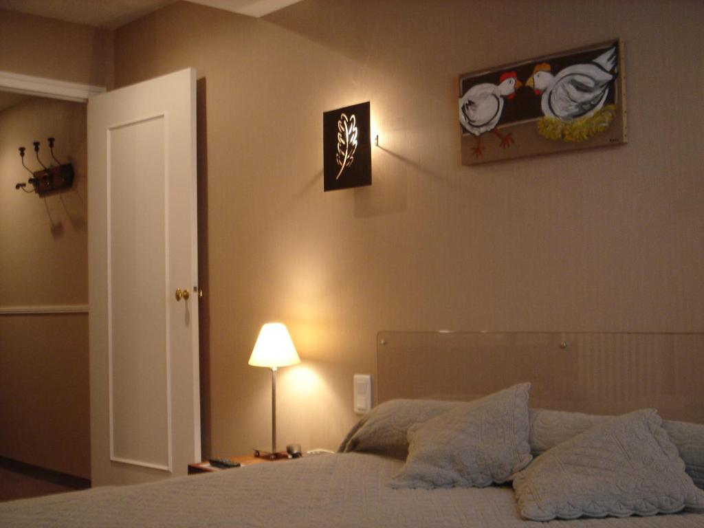 桑特Cit'Hotel des Messageries的一间卧室配有一张带灯的床,墙上挂着一张照片