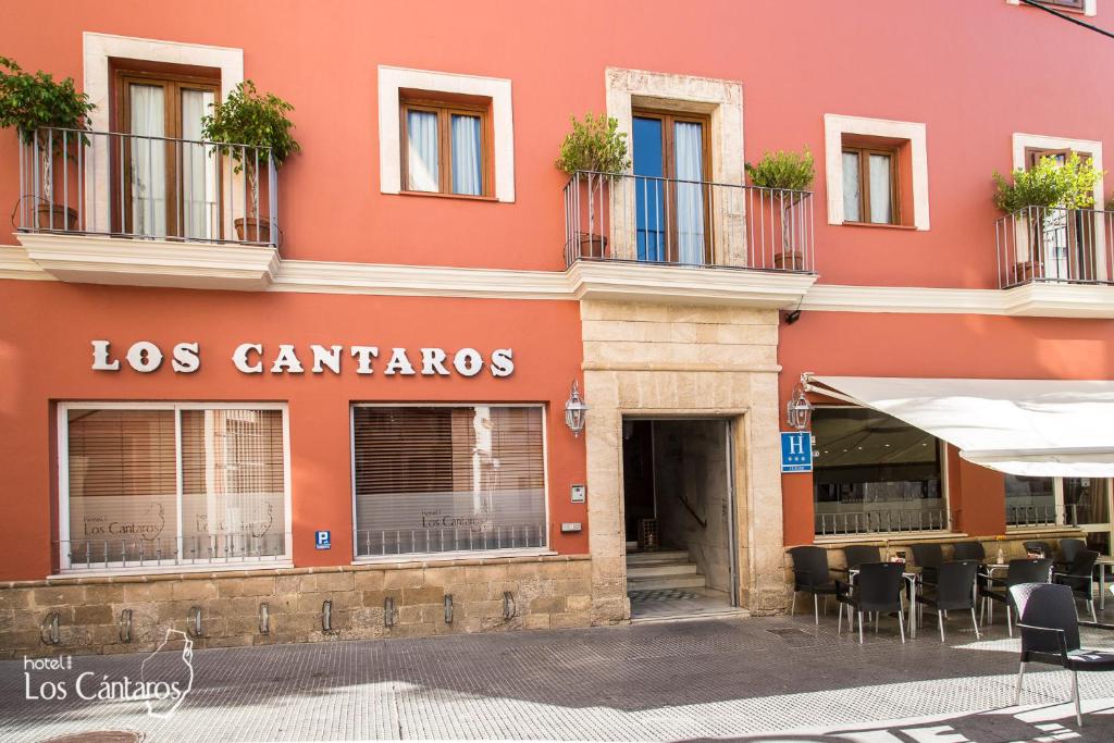 圣玛丽亚港洛斯坎塔洛斯酒店的前面有桌椅的红色建筑