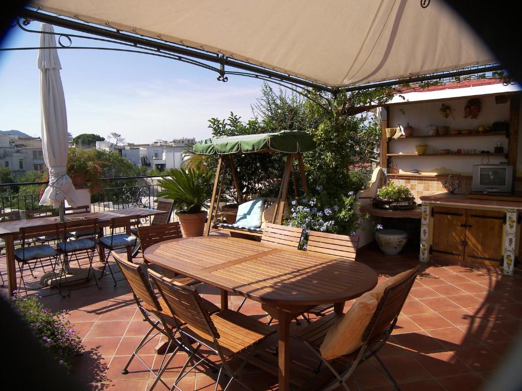 伊斯基亚Hotel Villa Verde的一个带桌椅和遮阳伞的庭院