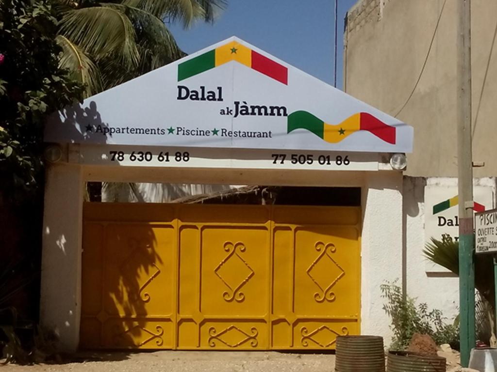 姆布尔Guesthouse Dalal ak Jàmm的黄色车库门,上面有标志