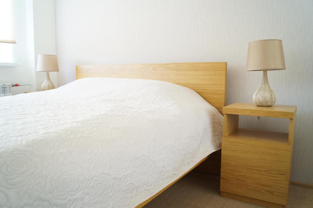 珀尔察马Marja Apartment的一间卧室配有一张床和一个带灯的床头柜