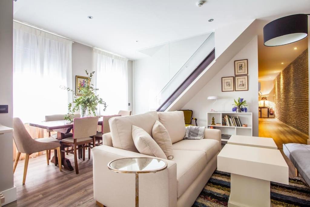 塞维利亚Apartamentos RG Dúplex San Bernardo的客厅配有白色的沙发和桌子