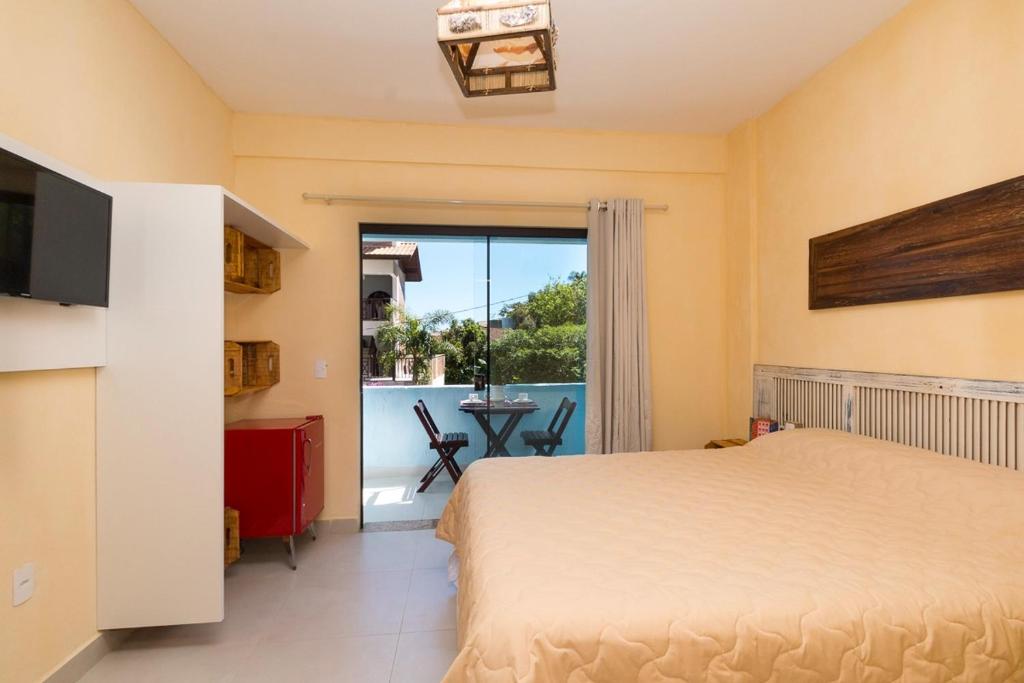邦比尼亚斯Vila Artesania的一间卧室设有一张床,享有阳台的景色