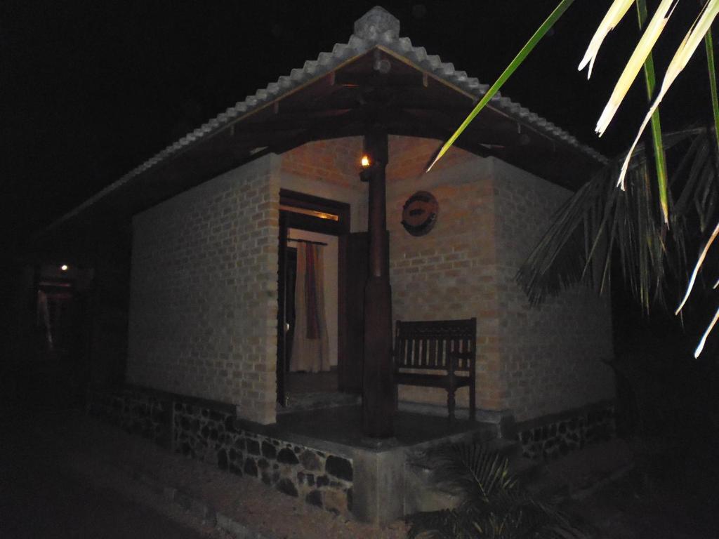 米瑞莎Lanrich Eco Villas的一座小建筑,在晚上前面有长凳