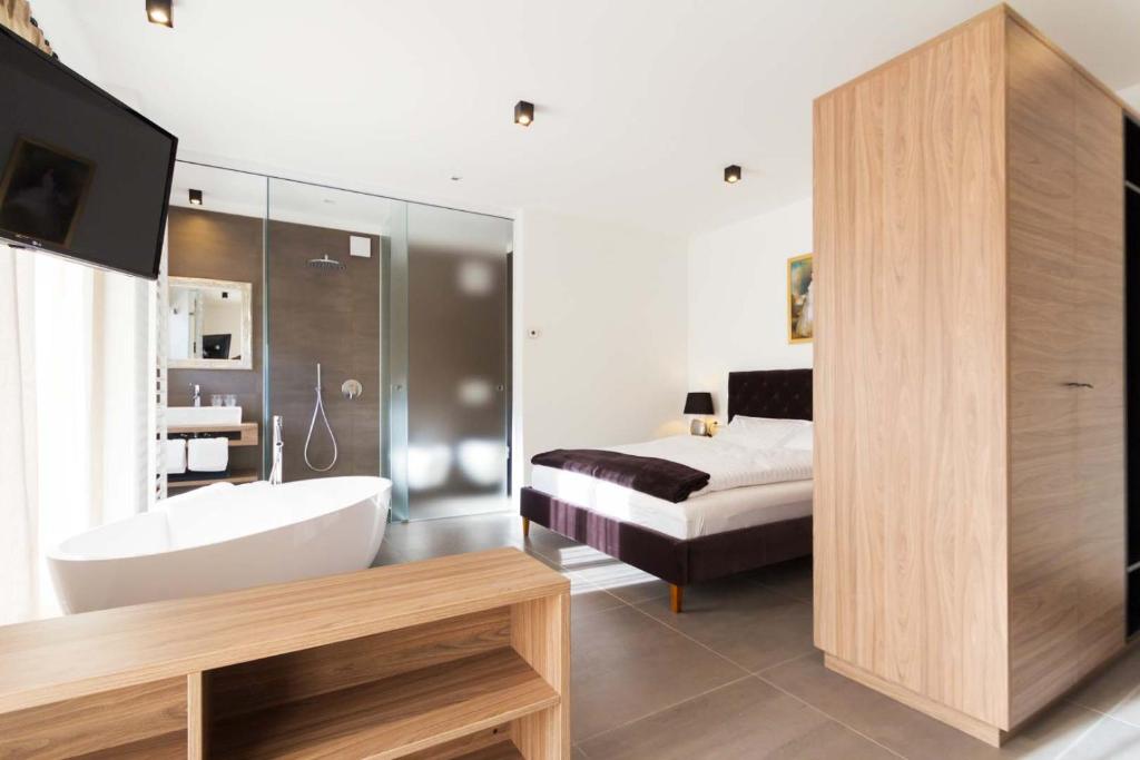 梅拉诺Apartments Sissi & Franz的带浴缸、床和电视的浴室