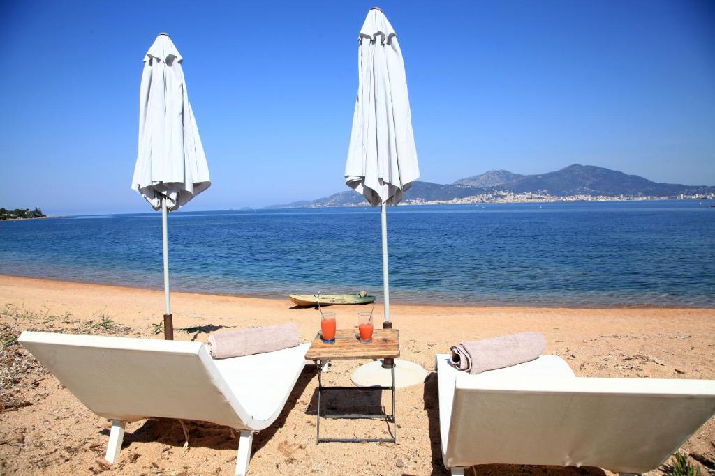 波尔蒂乔Villas les Residences de Scaglione的海滩上的两把椅子和一把遮阳伞