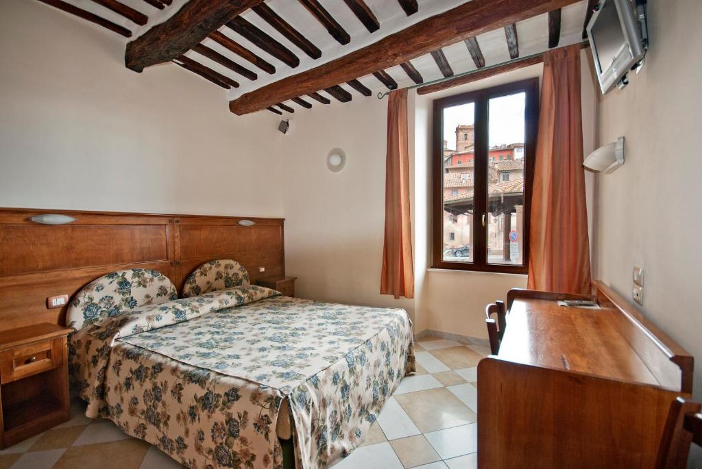 锡耶纳铝梅尔卡托酒店的一间卧室设有一张床和一个窗口