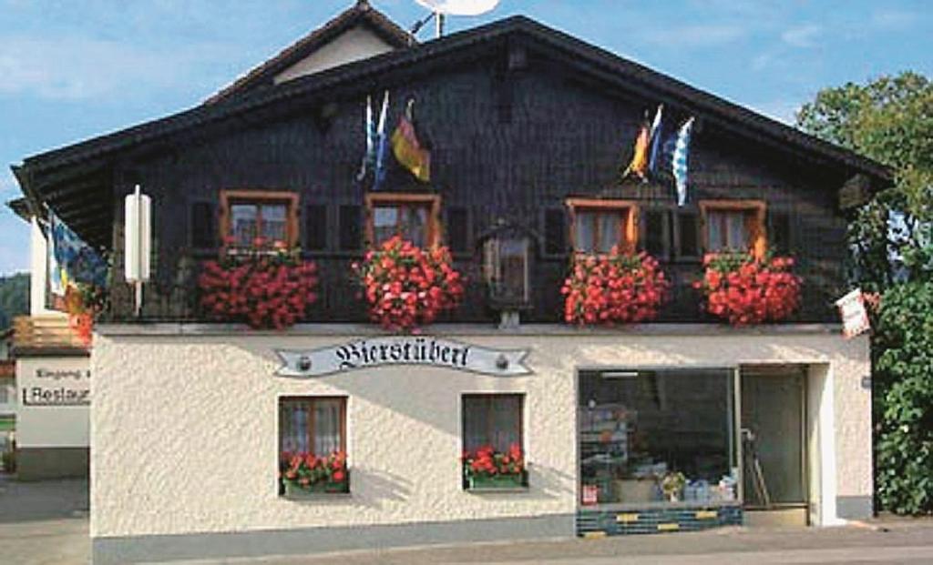 瓦尔德明兴Landgasthof "Altes Haus"的建筑前方有鲜花的商店