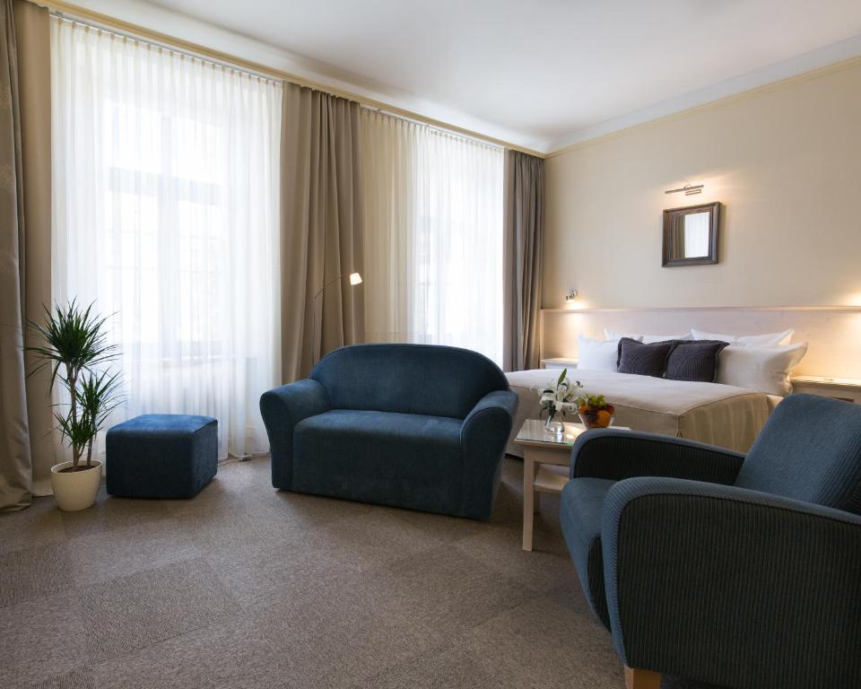 布拉格安盟酒店的酒店客房配有一张床、一张沙发和椅子。