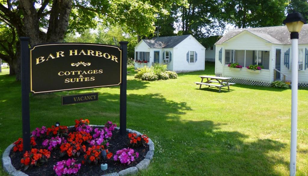 巴港Bar Harbor Cottages & Suites的房屋前花坛上的标志