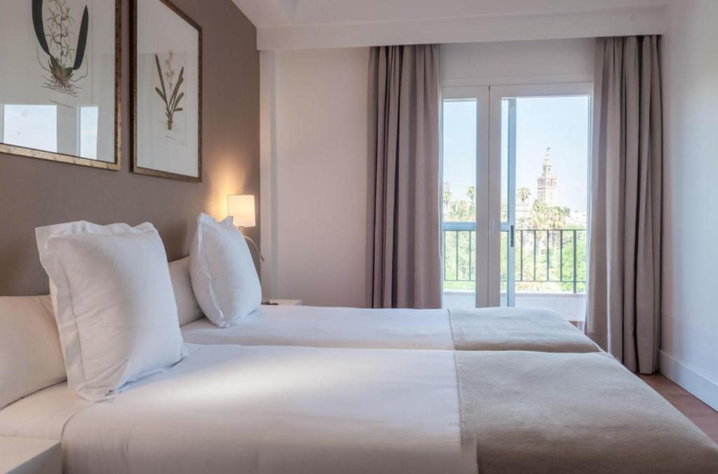 塞维利亚阿尔卡萨酒店的酒店客房设有两张床和窗户。