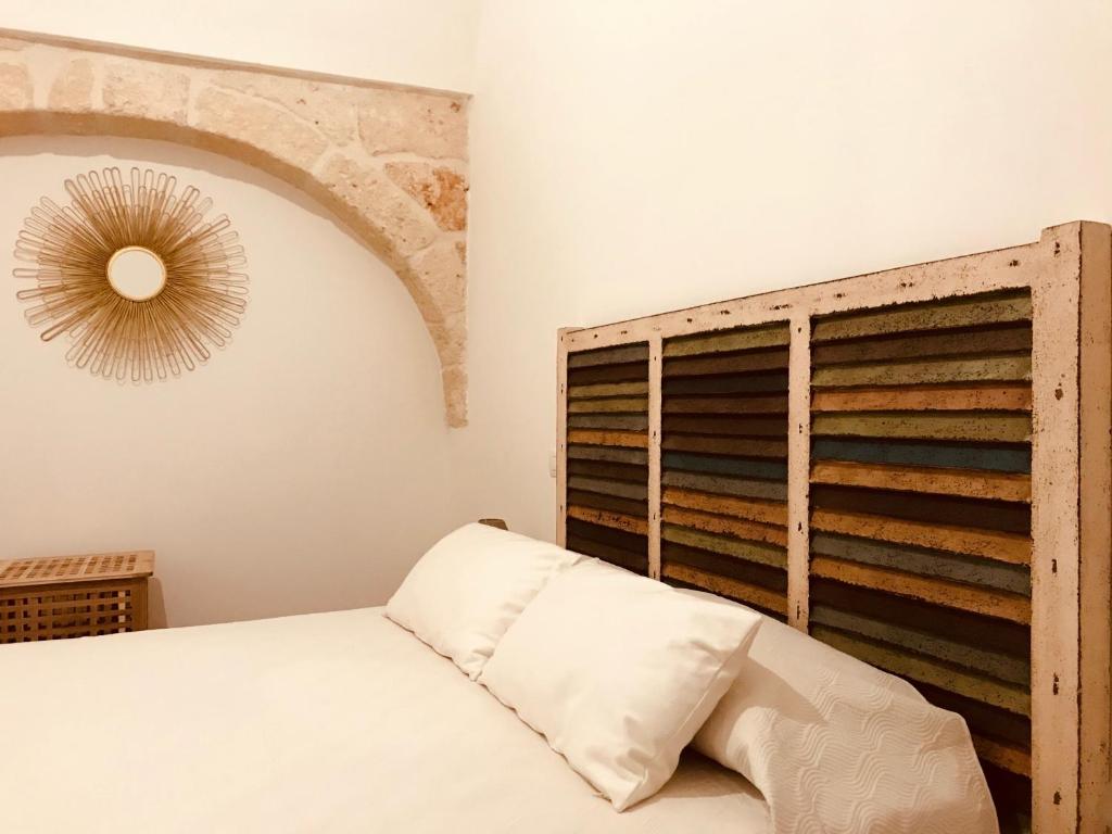 滨海波利尼亚诺Zì Marì - Via Sirene的一间卧室配有一张床和一个木制床头板