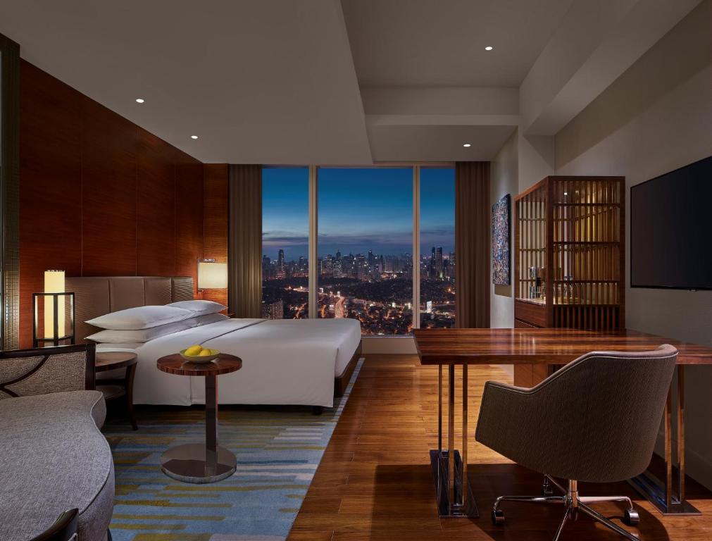 马尼拉Grand Hyatt Manila的酒店客房享有城市美景,配有一张床。