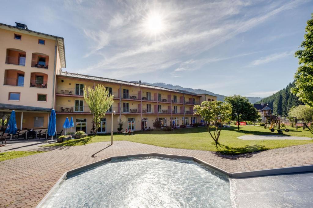 Veitsch法伊奇JUFA宾馆的一座带游泳池的度假村,位于一座建筑前