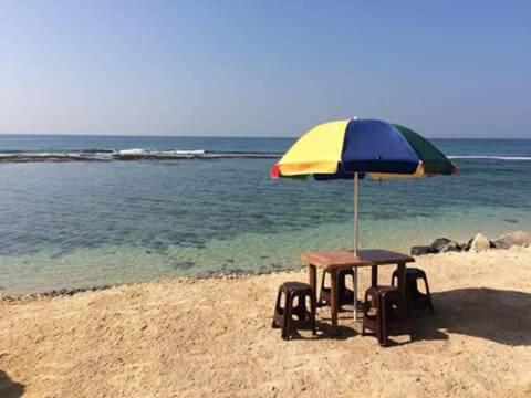 马特勒夕阳冲浪海滩度假村的海滩上遮阳伞下的桌椅