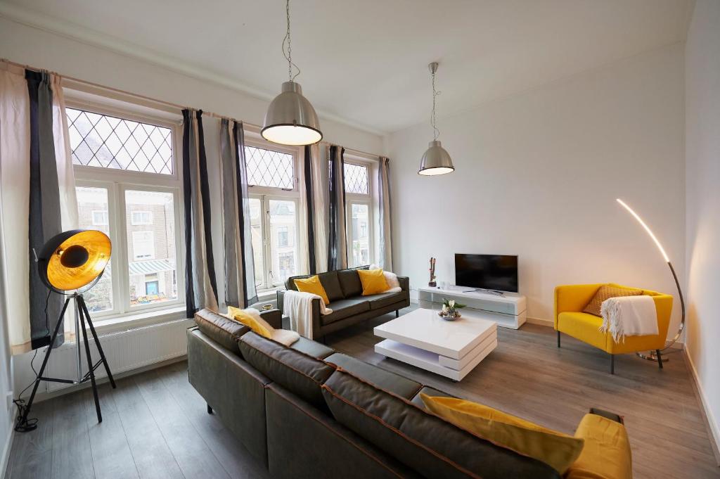哈林亨Harlingen oldtown apartment的客厅配有棕色沙发和黄色椅子