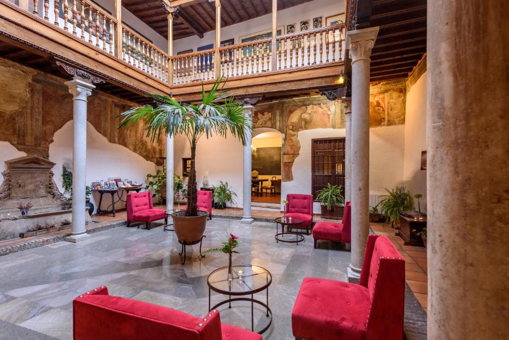 格拉纳达帕拉西奥德圣伊内斯酒店的室内大堂设有红色椅子和楼梯