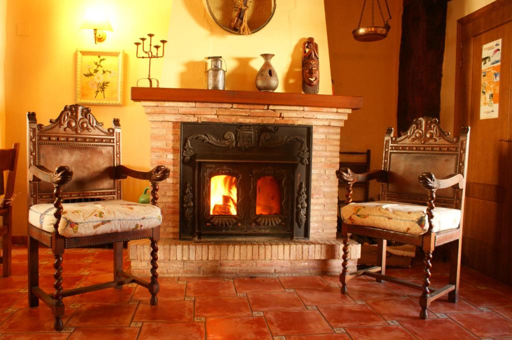 Ojacastro乌雅拉乡村民宿的壁炉前的两把椅子