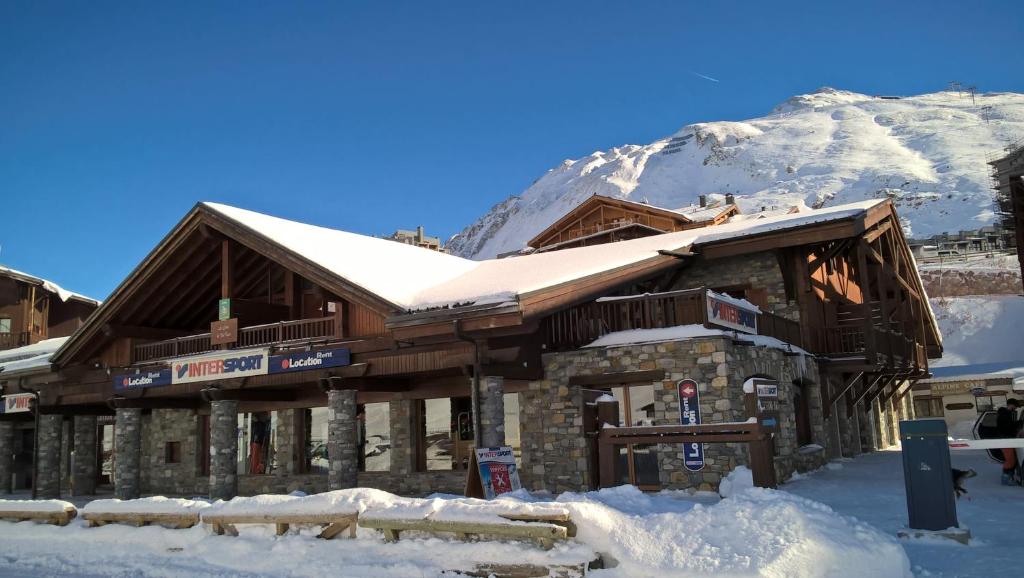蒂涅Les Suites du Val Claret的雪中与山间滑雪小屋
