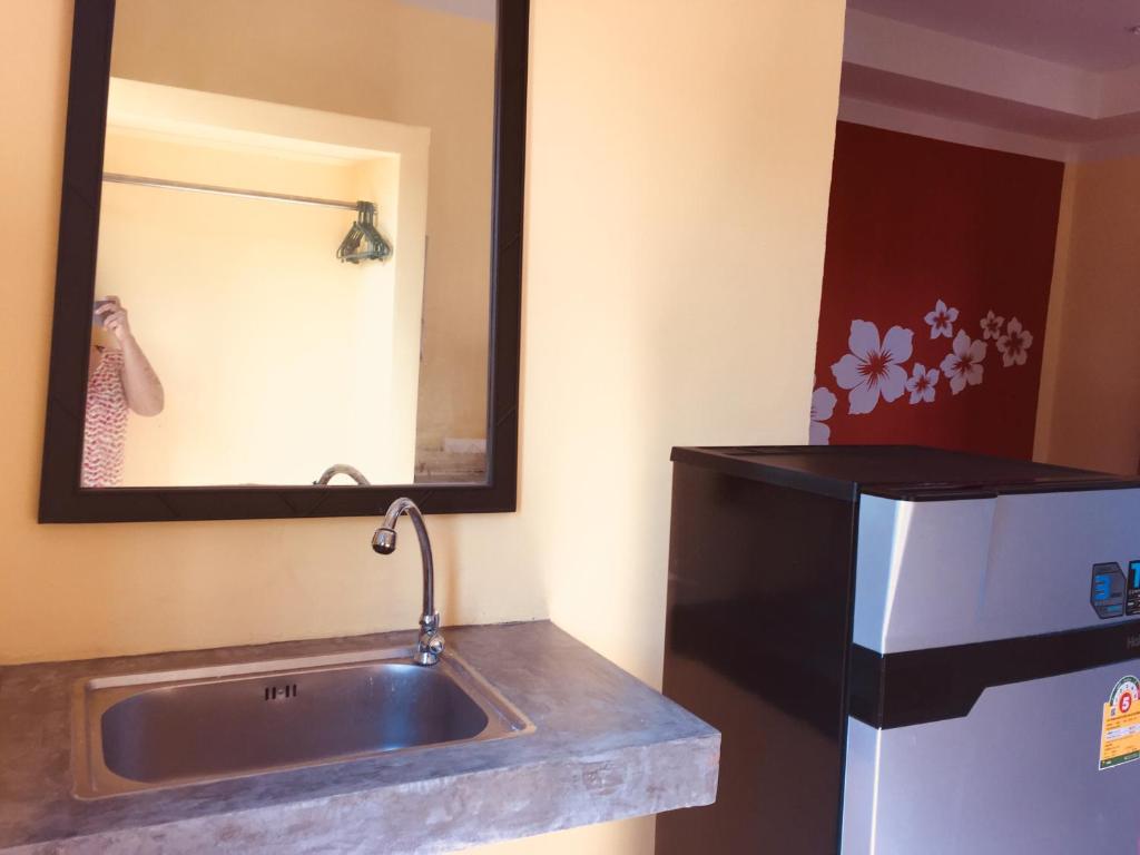 邦涛海滩寒冷之地旅馆的一间带水槽和镜子的浴室以及一台冰箱