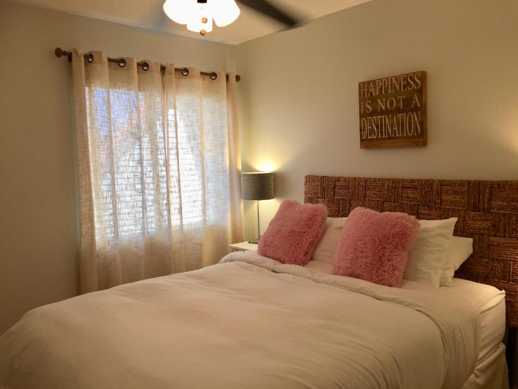 Tierra VerdeWander Residence Condo near Fort DeSoto的卧室配有白色床和粉红色枕头