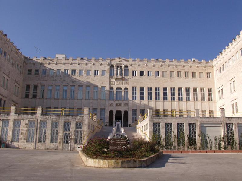 奥斯图尼Centro di Spiritualità Madonna della Nova的一座白色的大建筑,前面有一个庭院