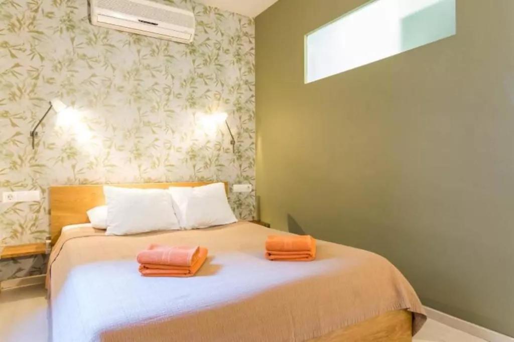 巴塞罗那Old City Beach House的一间卧室配有一张带两个橙色毛巾的床