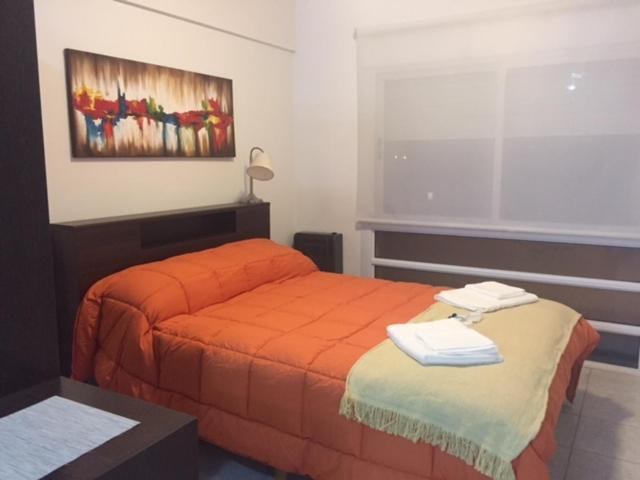 布兰卡港Las Marinas Rent的一间卧室配有一张带橙色毯子的床