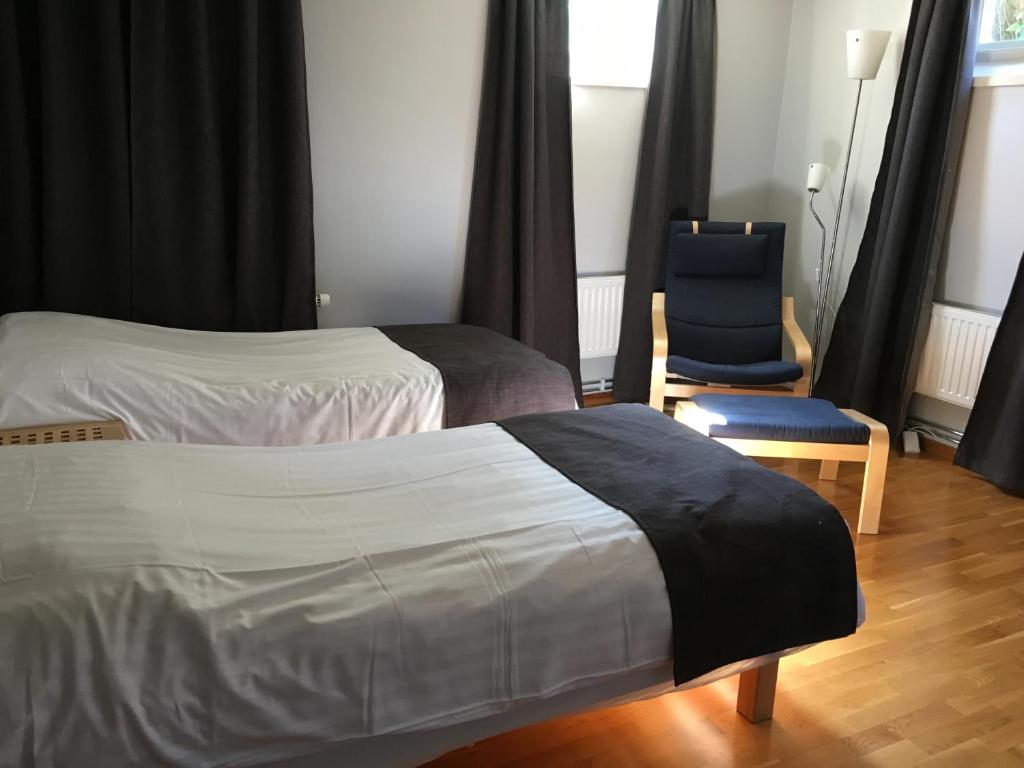 韦斯特罗斯Hotell Hässlö的酒店客房,设有两张床和一张蓝色椅子